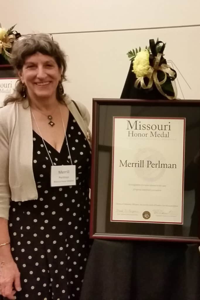 Merrill Perlman next to presentation award of Mussouri Honor Medal